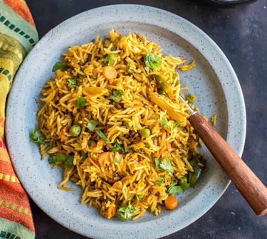 Veg Tawa Pulao - spicy, street-style rice tossed on a tawa with masalas, crunchy veggies, & butter.