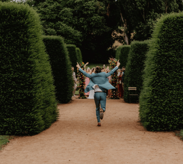 Marié courant dans les jardins d’un domaine de Provence lors d’un mariage festif et authentique