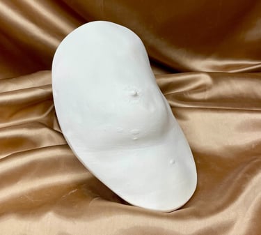 Moulage sein en plâtre sur fond doré