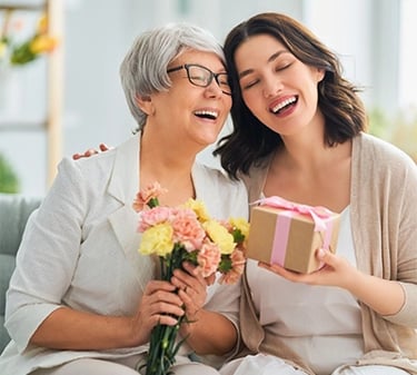 a woman holding a gift box with flowers