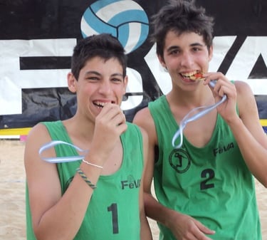 two boys are holding their medals in front of a banner