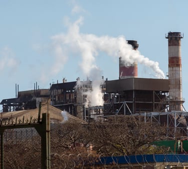 uma fábrica com fumaça saindo da chaminé