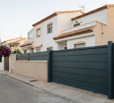 Puerta corredera metálica a medida con puerta peatonal en vivienda unifamiliar mediterránea