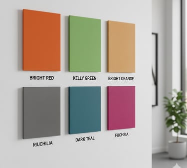 Six colorful acoustic wall panels in red, green, orange, grey, teal, and fuchsia on a white office wall.