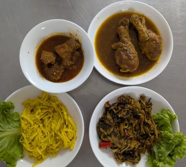 Variety of Burmese dishes including chicken drumstick curry, pork stew, and pickled bamboo shoots.