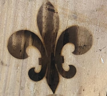 burned fleur de lis symbol into a piece of wood