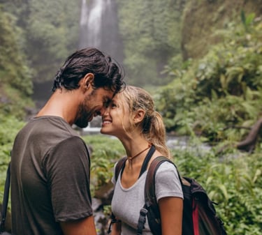 a man and woman standing in front of a waterfall at couples retreat in Mexico