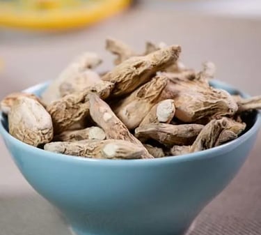 A blue bowl filled with dried ginger root pieces, a common spice used for cooking and herbal tea.