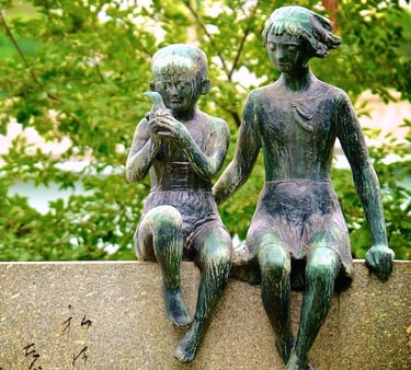 a couple of statues sitting on a stone wall