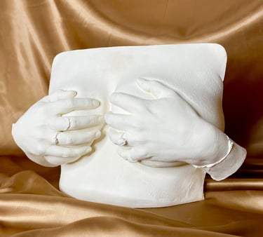 Moulage mains sur poitrine en plâtre sur fond doré