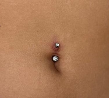 a woman with a piercing on her stomach