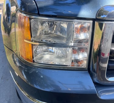 Blue truck seen from the front, with a shiny headlight after restoration, highlighting its new look.