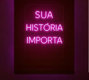 Cartaz com letras em neon na cor rosa do projeto Maria’s: Sua História Importa 