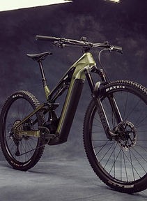 A high-performance full-suspension electric mountain bike with Maxxis tires in a professional studio setting.