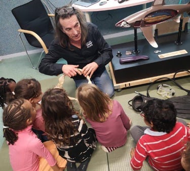 Alain Surina montrant une gueule de requins à des enfants de maternelle