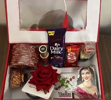 Red bridal gift hamper with Cadbury Dairy Milk chocolate, red bangles, lipstick, and bindi.