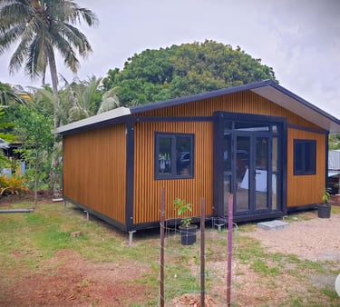 Modern wood-paneled prefabricated tiny house or backyard studio cabin with black glass doors.