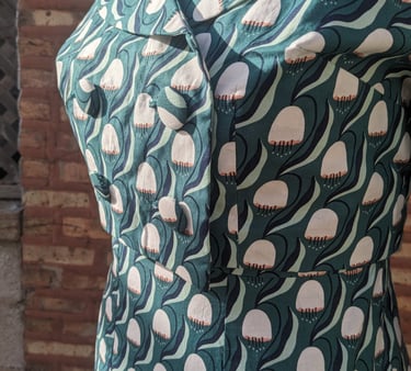 The front of a green art nouveau reversible sheath dress and 50's inspired cropped jacket