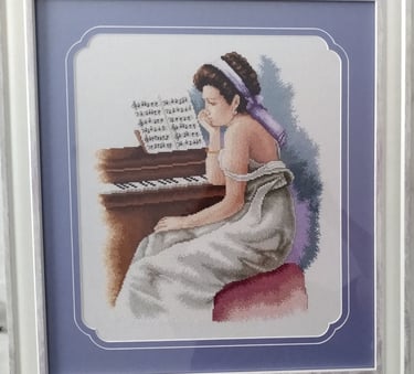 a woman in a white dress sitting at a piano