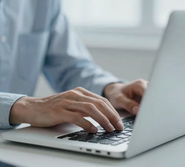 A close-up, sharp image of a professional using a laptop in a modern environment. The focus is on the precision and digital nature of the work. The environment is airy and professional, using a cool color palette centered around #A7BBCB and #F6F8FA.
