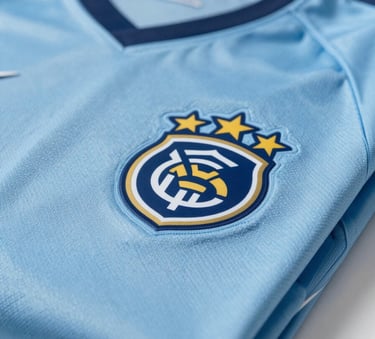 A close-up of premium, folded sports jerseys featuring a custom club logo, professionally lit with a clean aesthetic, incorporating #7A9EAF and #2F4858 tones.