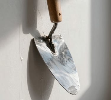 Extreme close-up of a steel trowel gliding smoothly over wet white plaster on a wall, sharp side lighting casting long shadows to show absolute flatness, clean architectural lines.