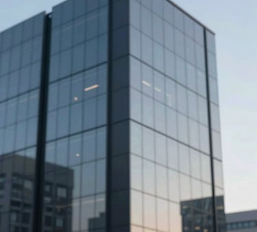 A modern office building exterior with clean glass lines reflecting a blue sky. Minimalist architectural style incorporating colors #1E3A4D and #4E7B99.
