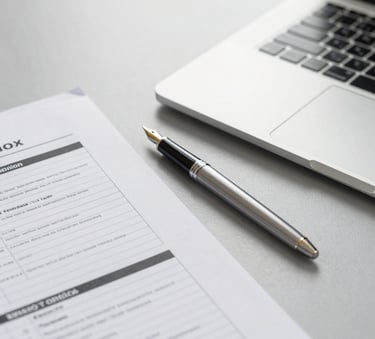 A close-up of a professional desk in an Italian office with a thin silver laptop, a high-quality fountain pen, and neatly organized tax documents on a light grey surface, bright and airy lighting.