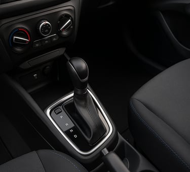 Interior de carro popular mostrando o câmbio automático entre os bancos dianteiros em destaque.