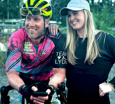 A picture of me (Justin) wearing cycling gear posing with another person (woman).
