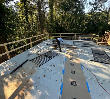 a man repairing a fence with metal on the floor of the driveway