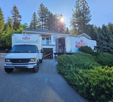 Canada’s Most Wanted Movers trucks loading at a hillside residential property in the Lower Mainland.