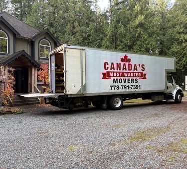 Canada’s Most Wanted Movers truck parked at a forest-side home in the Lower Mainland during a residential move.