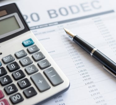A high-angle shot of a minimalist workspace with a calculator, a fountain pen, and financial spreadsheets, emphasizing precision and professionalism, with color accents in #546E7A and #B0BEC5.