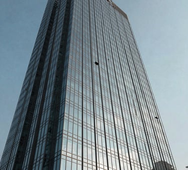 A low-angle shot of a modern glass skyscraper in Lahore reflecting a slate blue sky, emphasizing structural integrity and corporate scale.