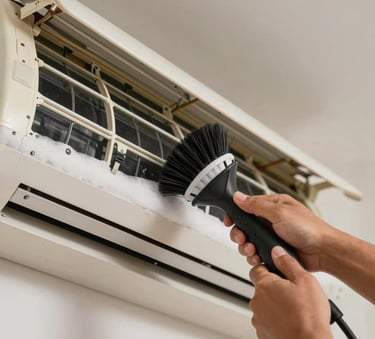 Close up of professional hands in a South American / Brazilian residential setting using a specialized cleaning brush and foam on the internal coils of an air conditioner, showing detailed maintenance process.