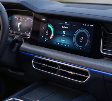 Close-up of a modern car dashboard with a high-tech interface, showing efficiency metrics, in a dark navy blue interior with soft light blue accents.