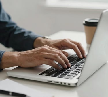 Close-up photography of a professional's hands using a high-end laptop in a minimalist, bright office in Madrid. The scene includes a coffee cup and clean stationery. Iberian Peninsula / Spanish.