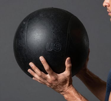 A detailed macro shot of a male athlete's hand holding a heavy medicine ball, professional studio lighting, charcoal background, premium sports aesthetic, North American / US style.