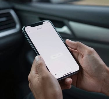 Close-up photography of a Southeast Asian / Indonesian person's hands holding a smartphone with a clean interface, sitting inside a comfortable car, soft evening light, mist grey interior.