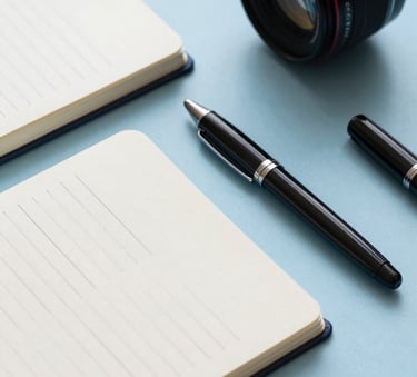 Close-up photography of corporate promotional gifts like branded notebooks and pens on a Misty Blue surface, professional and clean aesthetic.