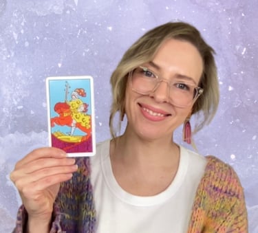 Natalie, founder of Crystal Aura Tarot, holding the Knight of Wands tarot card.
