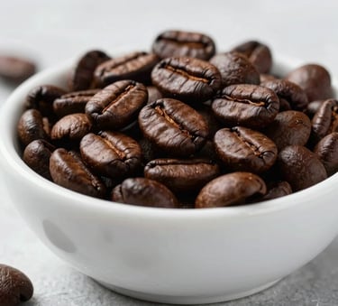 A clean, high-end close-up of dark roasted coffee beans in a white ceramic bowl, set on a minimalist ice grey surface with soft natural lighting.