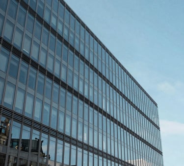 A minimalist architectural photograph of a modern financial office building in Paris, featuring clean glass lines reflecting a bright azure blue sky, European aesthetic, bright and precise lighting.
