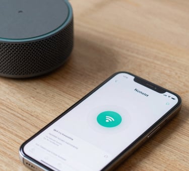 A close-up photograph of a smartphone screen showing a Wi-Fi connection interface next to a charcoal grey Echo Dot speaker on a light oak desk, North American / US home office setting, natural daylight, professional and clean composition.