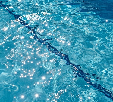 A close-up photograph of sparkling clear blue water in a South Florida residential swimming pool, sunlight glinting off the surface with professional high-definition clarity.