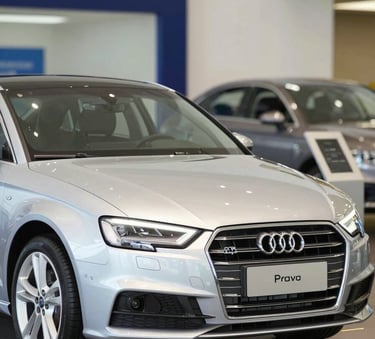 A high-quality, modern photograph of a silver Audi A3 parked in a bright, clean showroom. The composition is focused on the front of the vehicle, emphasizing its reliability and quality. The background includes subtle branding in #0A1128 and #F8C64F colors to create a professional dealership atmosphere.