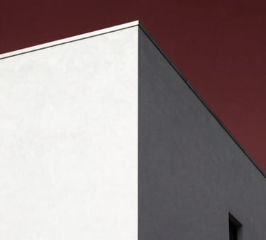 A minimalist architectural shot of a sharp, clean white corner against a deep dark red sky, reflecting power and clarity in a global metropolitan setting.