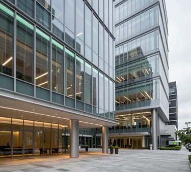 A wide-angle professional photograph of a modern North American / US corporate headquarters lobby, featuring sleek glass architecture and clean lines, with subtle mint and teal lighting accents.