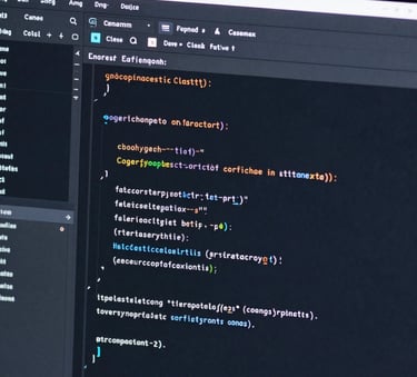 A close-up photography of a computer screen displaying clean, organized lines of code in a dark mode editor, with soft dusty blue light reflecting off the monitor edge in a dark navy room.